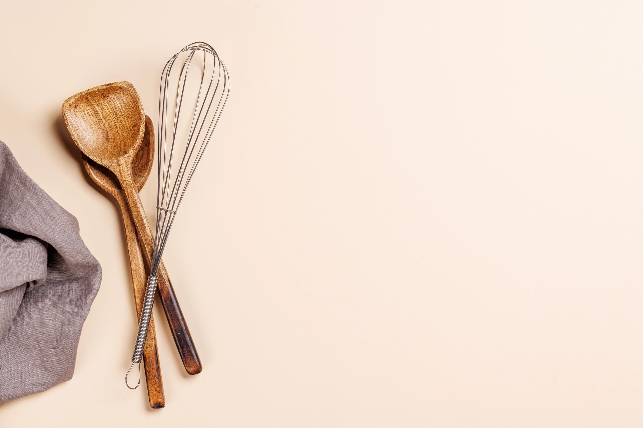 Flat lay of kitchen utensils on a neutral surface